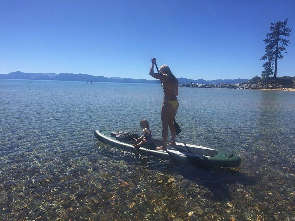 lady and child paddle boarding on a lake